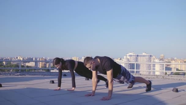 Skills fitness casal fazendo exercícios de perna no topo do telhado, perda de peso, força — Vídeo de Stock