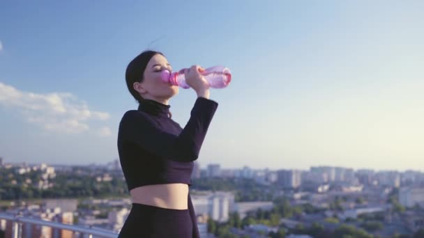 Şişeden su içen güzel bir sporcu kadın, su dengesi, sağlık hizmetleri. — Stok video