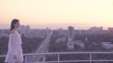 Tatlı bir çift öpüşüyor ve el ele tutuşuyor, büyük şehirde çatı randevusu, havada aşk.