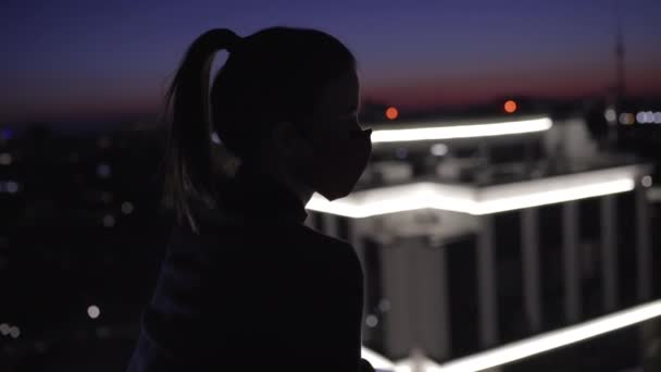 Vrouw met gezichtsmasker kijkt uit vanaf het dak, ontsnapt in het donker, bankoverval — Stockvideo