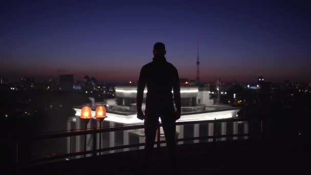 Homme dangereux en costume noir debout sur le toit la nuit, menace d'attaque terroriste — Video