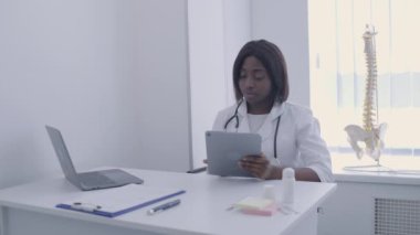 Hastanede tablet üzerinde çalışan bir tıp uzmanı, internetten hastanın kartını kontrol ediyor.