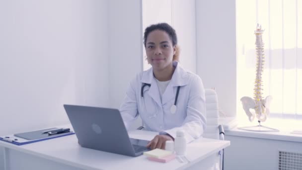 Médico afro-americano qualificado olhando para a câmera, trabalhando na clínica, hospital — Vídeo de Stock