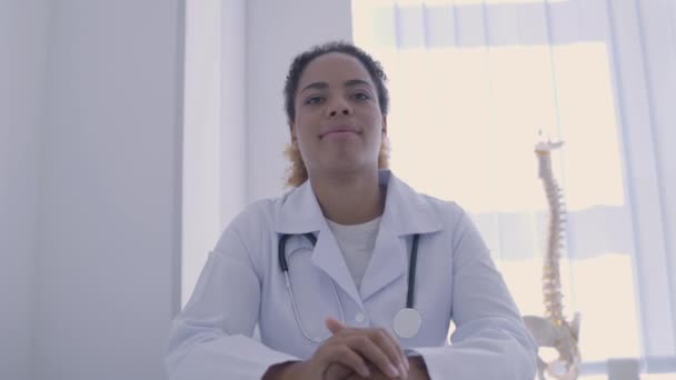 Mujer practicante sonriendo en la cámara, consulta en línea con el médico, salud — Vídeo de stock