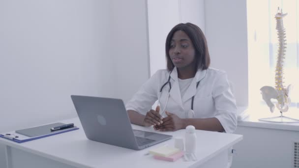 Médico profissional falando com o paciente on-line, sentado na frente do laptop, trabalho — Vídeo de Stock