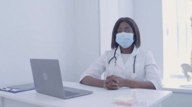 Maskeli Afro-Amerikan tıp çalışanı kameraya bakıyor, salgın kontrolü, virüs...