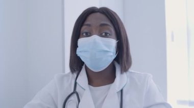 Maskeli kadın doktor kamerada konuşuyor, kovid19 için önleyici önlemler, sağlık