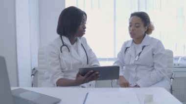 Kadın doktorlar el sıkışıyor, hastanın teşhisini tartışıyorlar, tıbbi ekip çalışması...