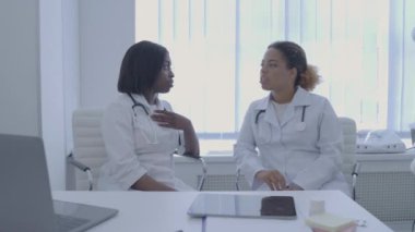 Profesyonel terapist ofiste stajyer doktorla konuşuyor, tecrübelerini paylaşıyor.