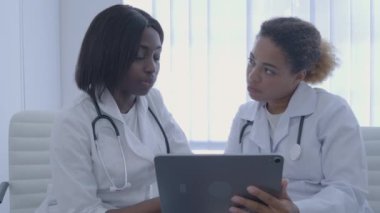 Tıbbi uzman stajyere tablet uygulamasını, klinikte stajı nasıl kullanacağını anlatıyor.