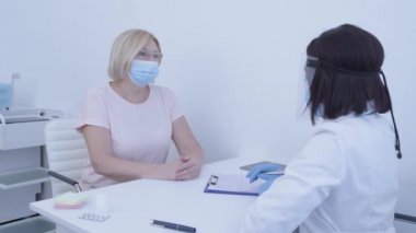 Maskeli kadın hasta doktoru dinliyor, fiziksel muayene, karantina...