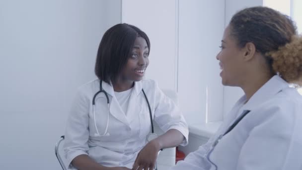 Усміхнені медсестри говорять, обговорюють роботу, дружню атмосферу на роботі, команда — стокове відео