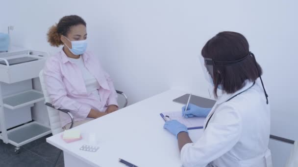 Arzt überprüft die Temperatur des Patienten, schreibt in die Karte, Symptome des Coronavirus — Stockvideo