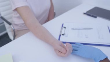 Doktor hastanın bileğindeki ısıyı, klinik muayeneyi, virüsü kontrol ediyor.