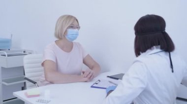 Hastayı muayene eden hemşire, alnındaki ısıyı ölçen hemşire, hastalık belirtileri.