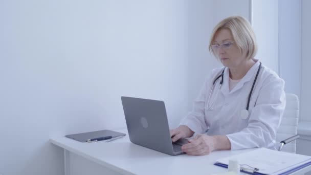 Clinica specialista digitando sul computer portatile in ufficio, compilare documenti online, app — Video Stock