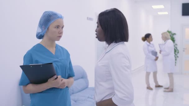 Afro-Amerikalı doktor, kadın hemşireye hasta tedavisi ve hastane hakkında bilgi veriyor. — Stok video