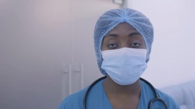 Aşırı çalışan siyahi sağlık görevlisinin üzgün yüzü, gece vardiyasından sonra yorgun düşen doktor.