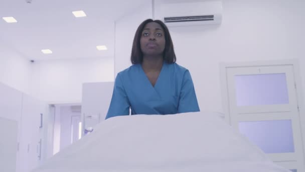 Enfermeira séria empurrando cuidadosamente maca na sala do hospital, serviços de saúde — Vídeo de Stock