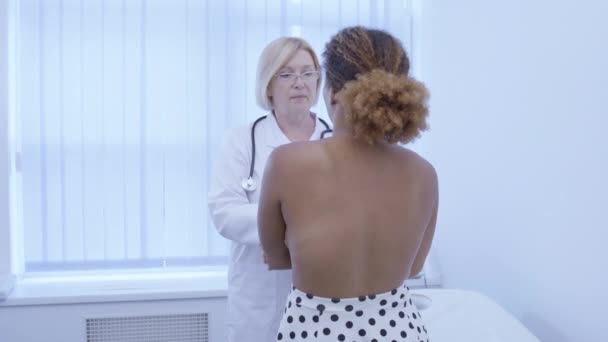 Chirurgien plasticien examinant les seins de la jeune femme, planification procédure d'augmentation — Video