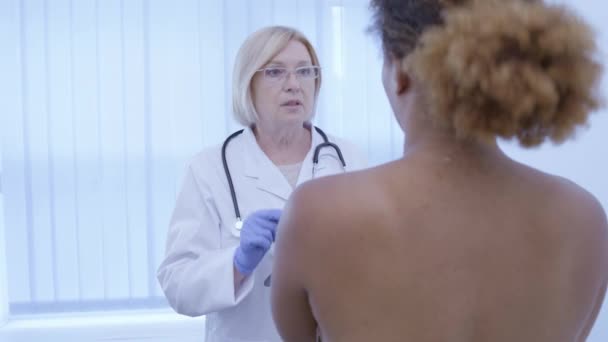 Mujer médico dando recomendaciones paciente mujer después del examen de cuidado de mama — Vídeos de Stock