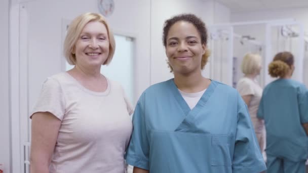 Счастливый пациент и врач улыбаются в камеру, успешное восстановление, реабилитация — стоковое видео