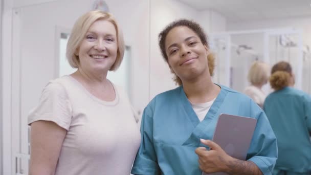 Veselý lékař objímající starší pacientku, usmívající se vačka, zdravotní péče — Stock video