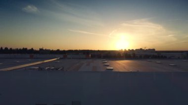 Günbatımı arka planında endüstriyel şehir manzarası, büyük depolama tesisi