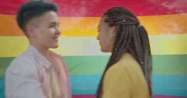 lgbt gökkuşağı bayrağı yakınında birbirine sarılan çok ırklı çift, aşk ve destek ilişkisi