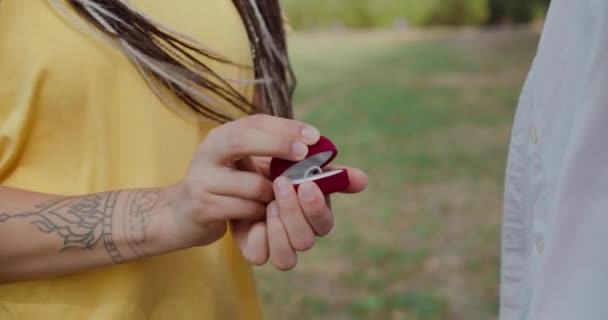 Νεαρή γυναίκα που κρατά δαχτυλίδι σε κουτί δώρου, προτείνοντας να παντρευτεί, ομοφυλόφιλο ζευγάρι — Αρχείο Βίντεο