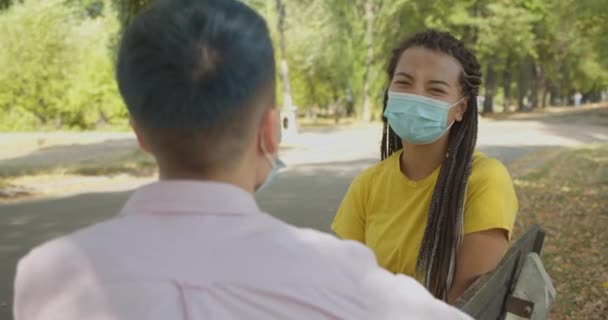 Ung asiatisk kvinna i skyddsmask pratar med vän utomhus, hälsovård — Stockvideo