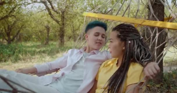 Relajada pareja gay descansando en hamaca, pasando tiempo juntos al aire libre, amor — Vídeos de Stock