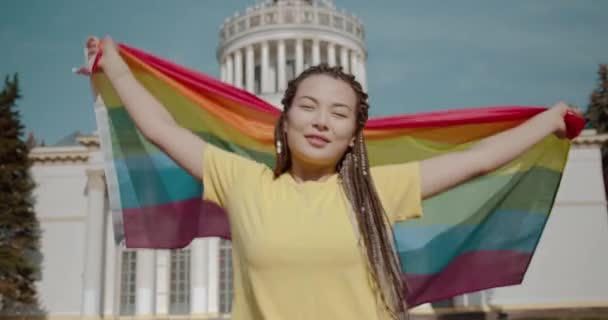 Gelukkig aziatisch meisje met lgbt regenboog vlag, genieten van de vrijheid van meningsuiting — Stockvideo