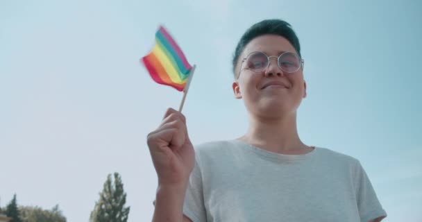 Pemuda yang memegang bendera pelangi dan tersenyum, mendukung persamaan hak — Stok Video