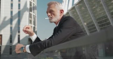 Gergin ofis çalışanı dışarıda sigara içiyor, stres atağı, sağlıksız alışkanlık, gerilim
