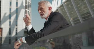 Stresli bankacı dışarıda sigara içiyor, iş yerinde depresyonda, endişeli.