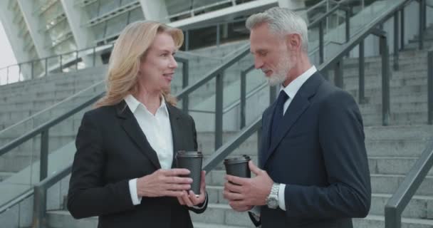 Leende kontorskollegor diskuterar arbetsnyheter som håller koppar kaffe, team — Stockvideo