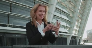 Akıllı telefonda mobil uygulama kullanan mutlu iş kadını, aygıt üzerinde planlama çizelgesi