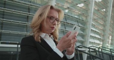 Üzgün kadın görme sorunu yaşıyor, alet kullanmak için gözlük takıyor.