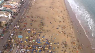 Sahilde ve denizde arka planda şehirler var.  