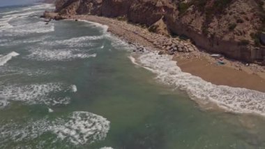 Apollonia Ulusal Parkı, İsrail 'de dalgalar ve turistler çarpışıyor. Hava aracı görüntüsü 4k