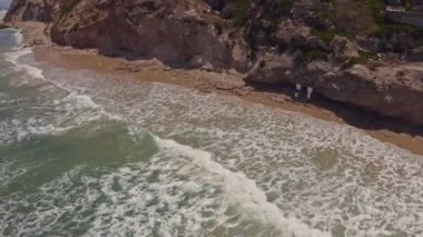 Apollonia Ulusal Parkı, İsrail 'de dalgalar ve turistler çarpışıyor. Hava aracı görüntüsü 4k