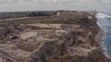 Apollonia Ulusal Parkı, İsrail 'de dalgalar ve turistler çarpışıyor. Hava aracı görüntüsü 4k