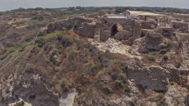 Apollonia Ulusal Parkı, İsrail 'de dalgalar ve turistler çarpışıyor. Hava aracı görüntüsü 4k