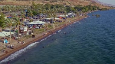 Kalabalık bir sahil ve Kineret, Tiberias, İsrail sahillerindeki kamp insansız hava aracı görüntüsü.