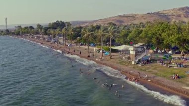 Kalabalık bir sahil ve Kineret, Tiberias, İsrail sahillerindeki kamp insansız hava aracı görüntüsü.