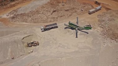 Ağır traktör inşaat alanında taş taşıyor, hava aracı görüntüsü 4k