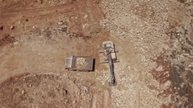 Kazıcı taşları gelecekteki bir inşaat alanında kamyona yüklüyor, hava aracı görüntüsü 4k