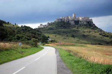 Gökyüzüne ve bulutlara karşı bir tepeüzerinde antik kale.