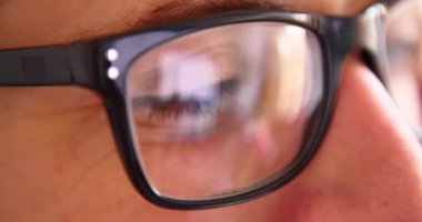 Sohbet yazarak, yansıma gözler gözlük yakın çekim smartphone kullanarak çekici genç adam.